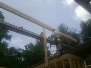 Carpenter setting a ridge beam over a new addition frame — Ice Dam Removal by Roofing Brothers in Othello