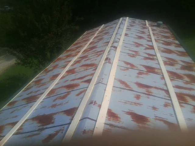 Rusted metal roof panels with new wood purlins before replacement — Storm Damage Roof Repair in Othello by Roofing Brothers